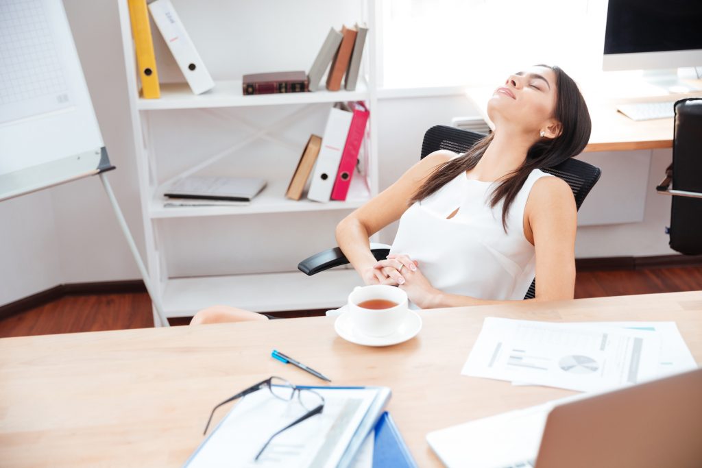 Beautiful businesswoman relaxing at her workplace in office