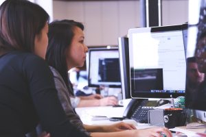Two women coding together at a coworking space.