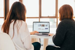 Two women collaborating on a project together.