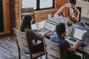 Employees sitting around a table working.