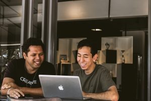Two men smiling and showing why coworking is fun.