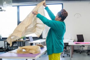 A woman working on a sewing project at a coworking space.