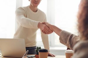 Two people shaking hands after signing a coworking contract.