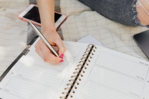 A woman writing in a planner.