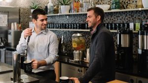 Two men talking in a coworking space.