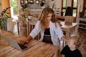 A woman distracted while working from home by her child.