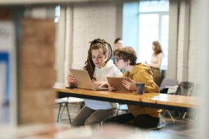 Two women remote working together in a coworking space.